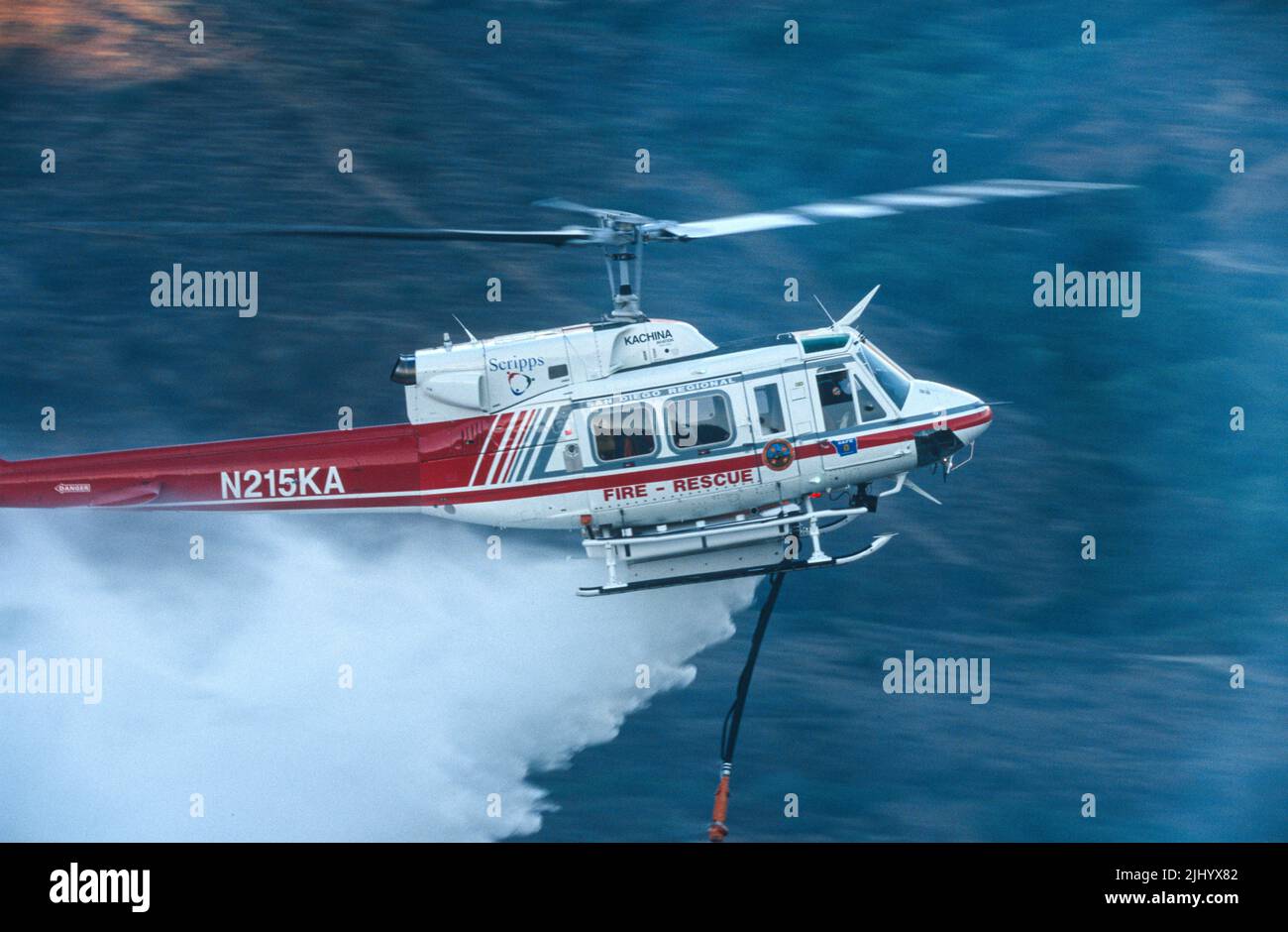San Diego Regional Fire-Rescue Hubschrauber von Kachina Aviation macht einen Wassertropfen auf einem funktionierenden Wildland (Pinsel) Feuer. Stockfoto