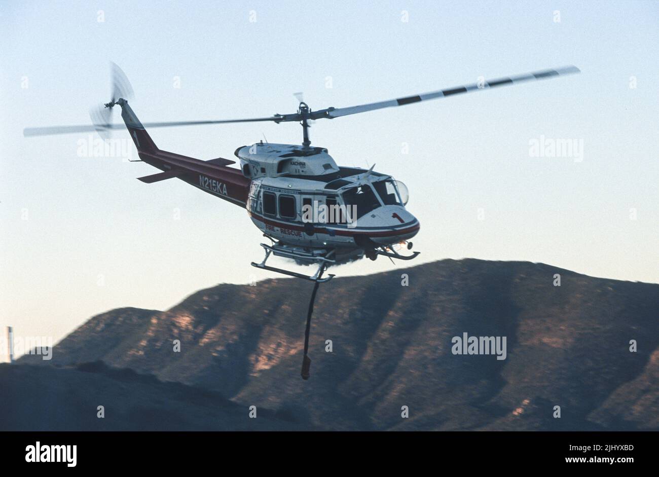San Diego Regional Fire-Rescue Hubschrauber von Kachina Aviation macht einen Wassertropfen auf einem funktionierenden Wildland (Pinsel) Feuer. Stockfoto
