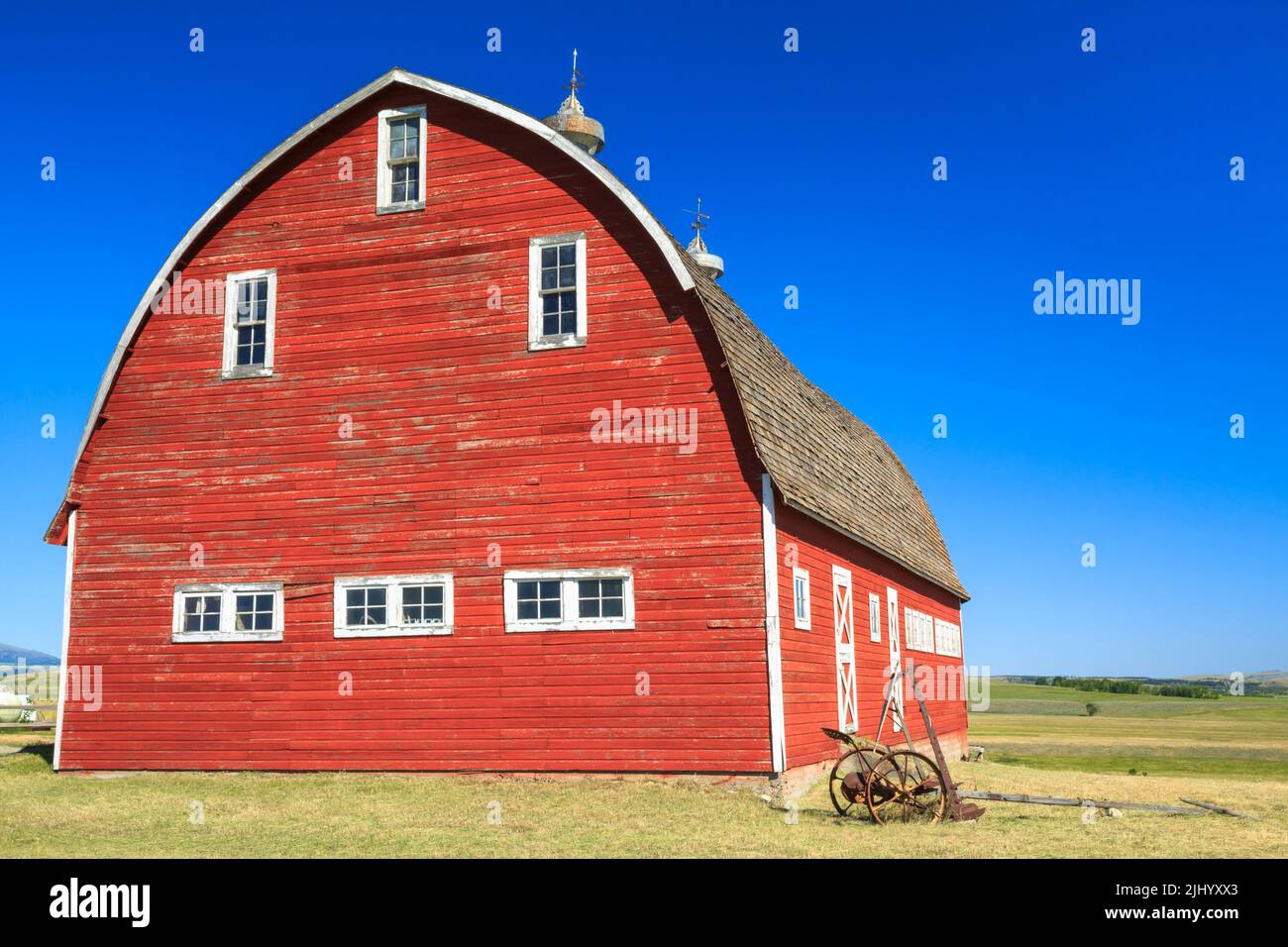 Alte rote Scheune auf Baumwollholzbank in der Nähe von clyde Park, montana Stockfoto