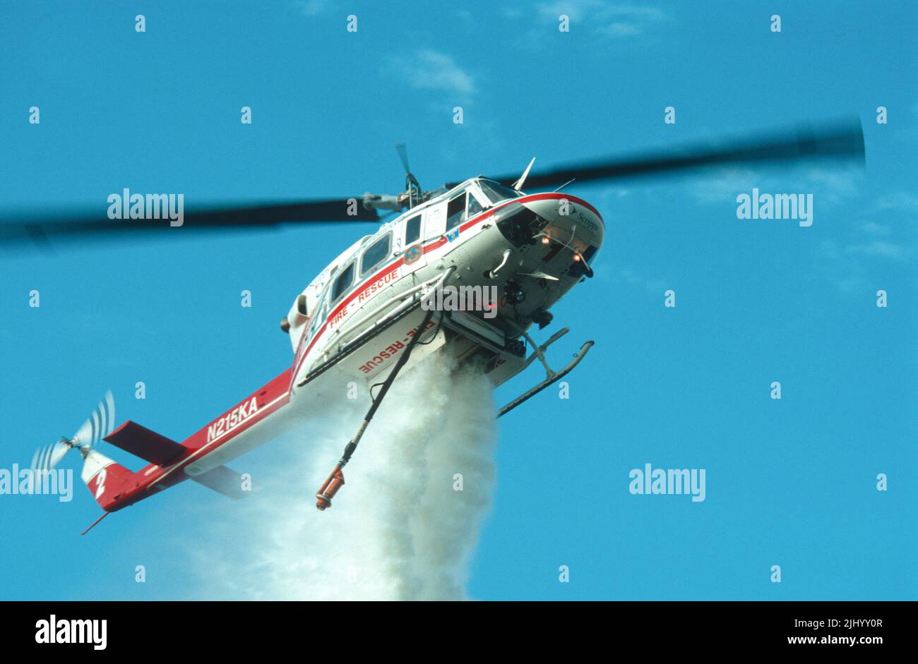 San Diego Regional Fire-Rescue Hubschrauber von Kachina Aviation macht einen Wassertropfen auf einem funktionierenden Wildland (Pinsel) Feuer. Stockfoto