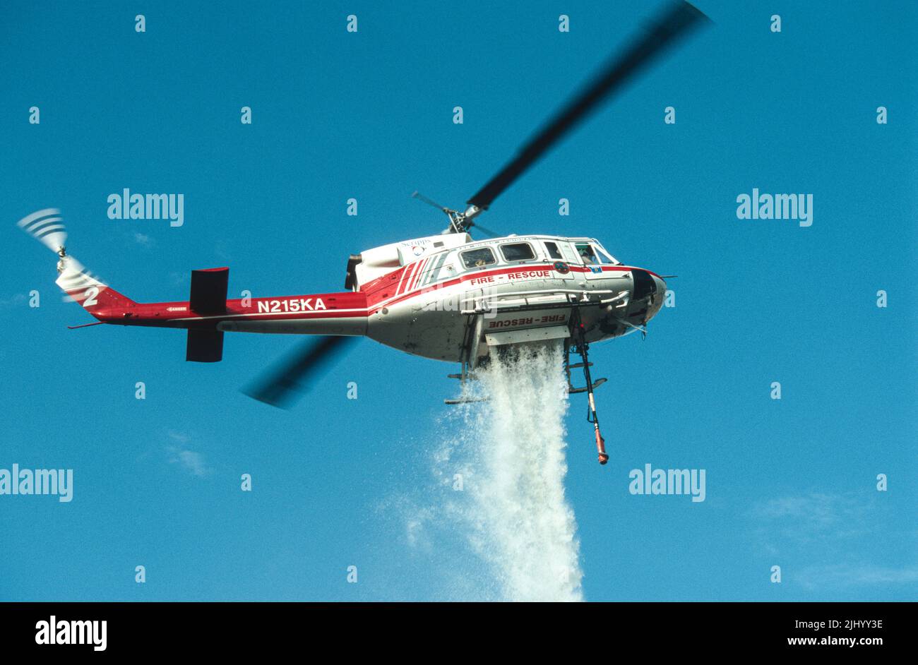 San Diego Regional Fire-Rescue Hubschrauber von Kachina Aviation macht einen Wassertropfen auf einem funktionierenden Wildland (Pinsel) Feuer. Stockfoto