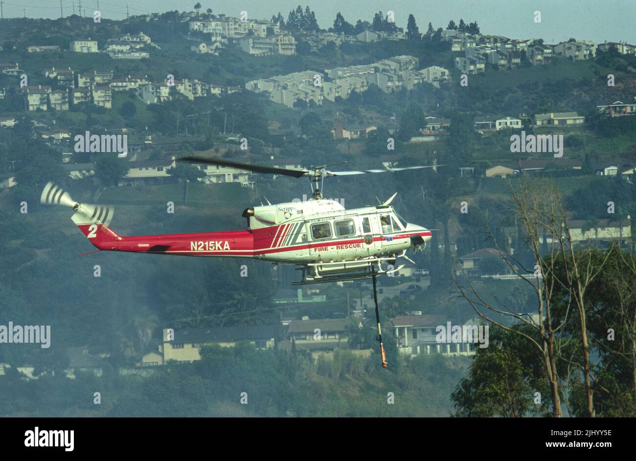 San Diego Regional Fire-Rescue Hubschrauber von Kachina Aviation macht einen Wassertropfen auf einem funktionierenden Wildland (Pinsel) Feuer. Stockfoto