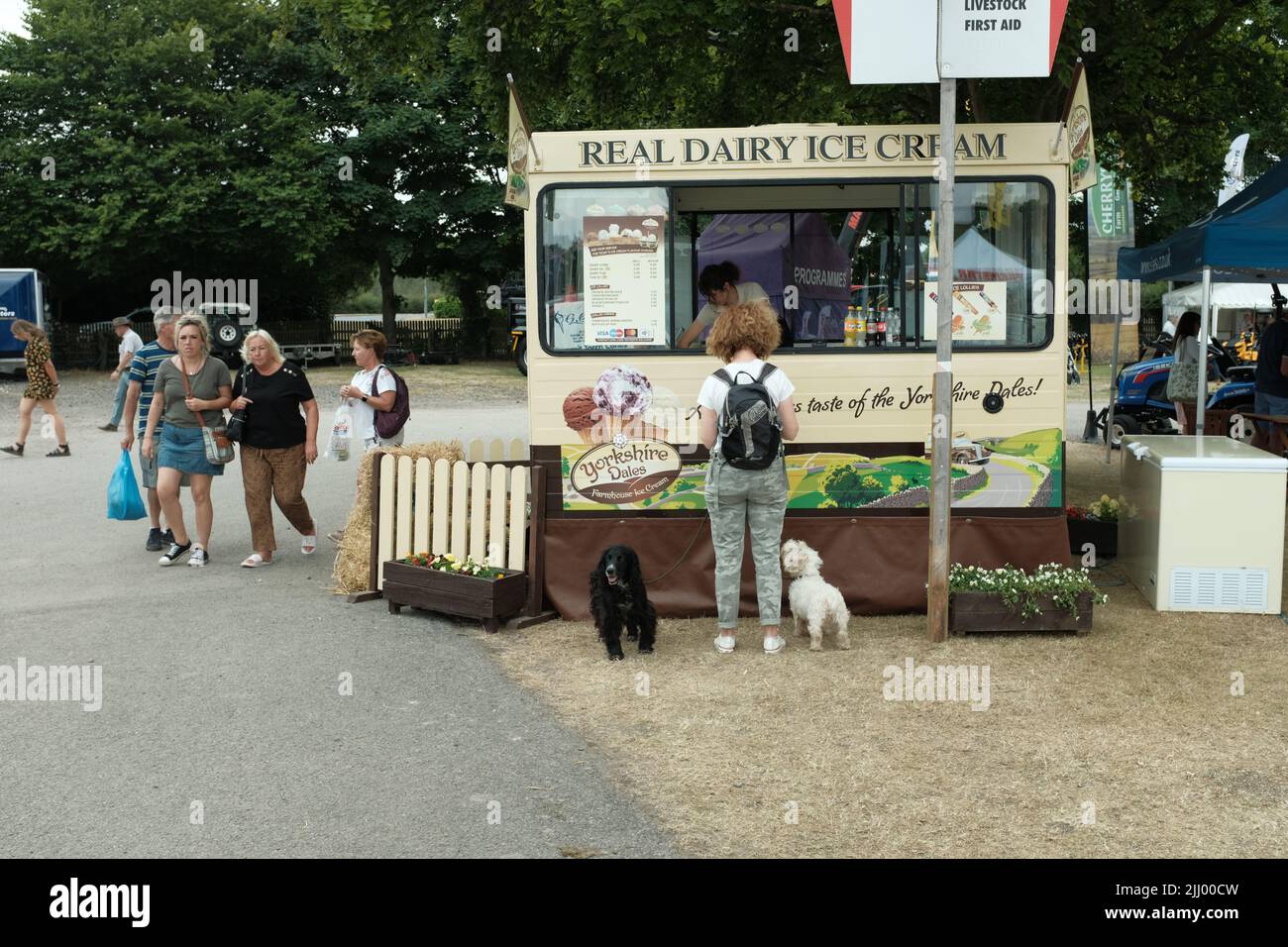 Ein Ausstellungsbesucher mit zwei Hunden kauft ein Eis in einem Eiswagen auf der Driffield Agricultural Show, Yorkshire, England, Juli 2022 Stockfoto