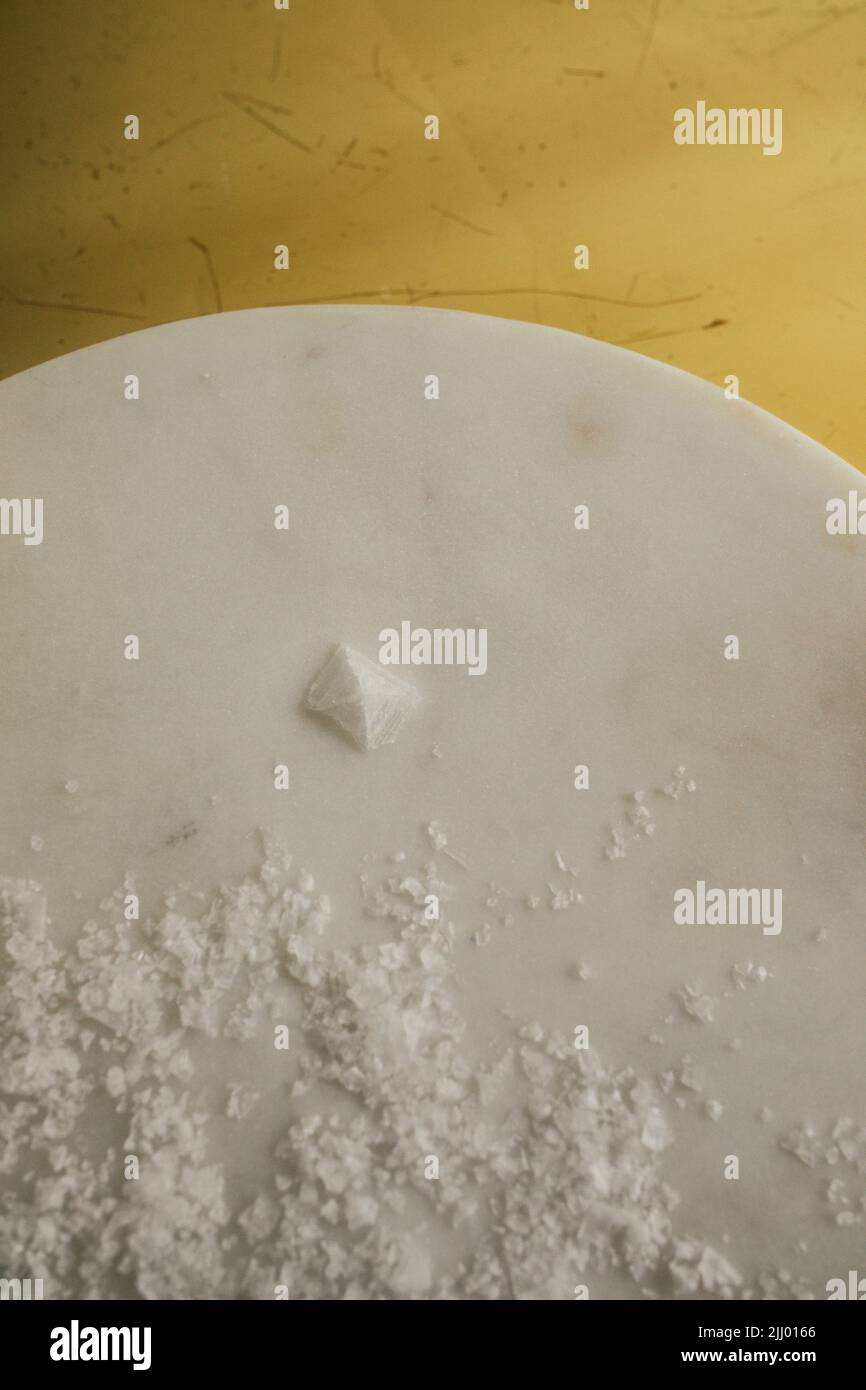 Maldon-Salzflocken mit einem einzigen pyramidenförmigen Salzkristall Stockfoto