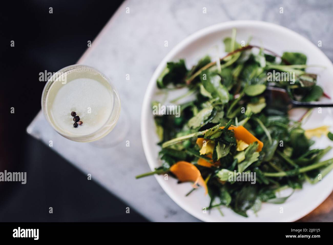 Wildwasser-Salat mit Erbsen und Orangenmimolette Stockfoto