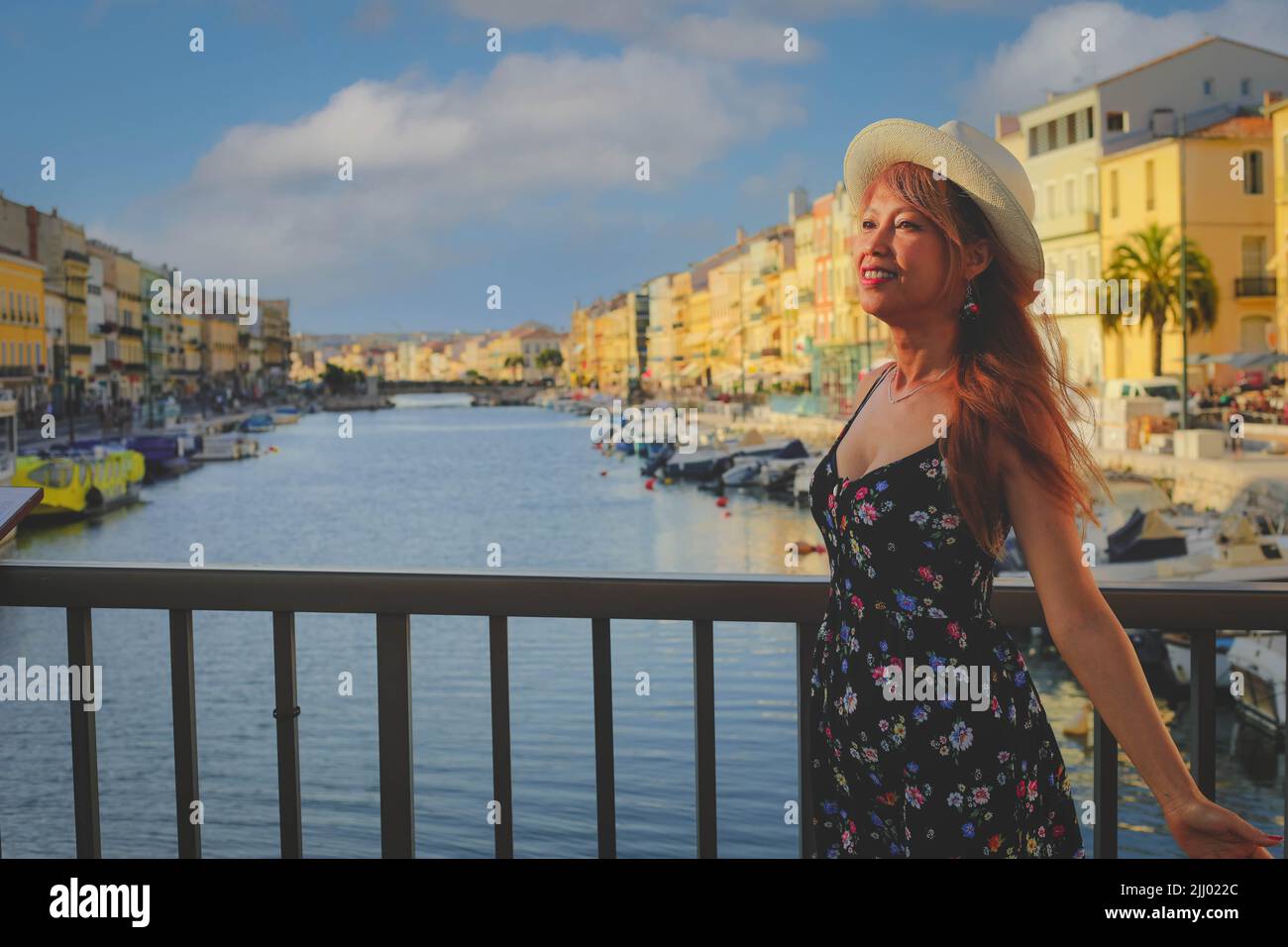 Junge Frau im Sommerkleid, die auf der Brücke in Sete steht, einem der Top-Reiseziele in der Region Oskitanie, Südfrankreich Stockfoto