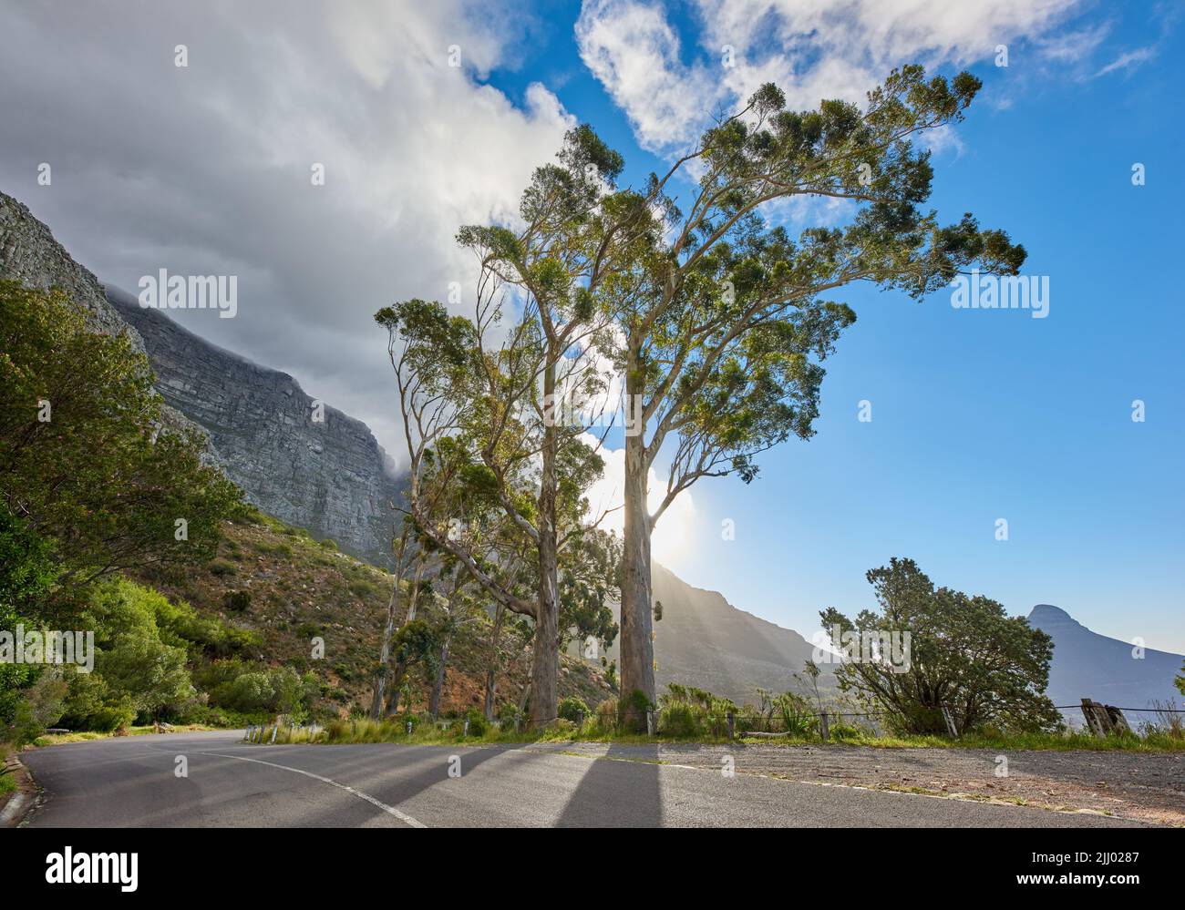 Eine Straße, die an einem sonnigen Morgen zum Tafelberg in Kapstadt, Südafrika, führt, gegen einen blauen Himmel. Eine Autobahn entlang eines friedlichen Berges Stockfoto