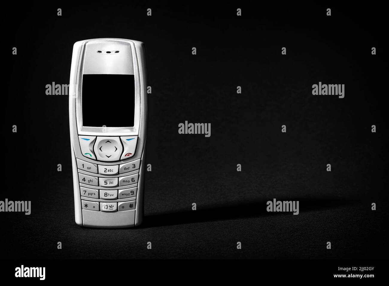 Altes silbernes Telefon mit Knöpfen auf schwarzem Hintergrund. Stockfoto