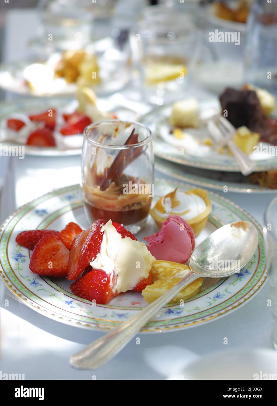 Nahaufnahme von süßem Dessert, serviert auf Porzellantellern und Gerichten bei einem High-Tea-Event oder einem gehobenen Restaurant. Textur Detail von leckeren Erdbeeren Stockfoto