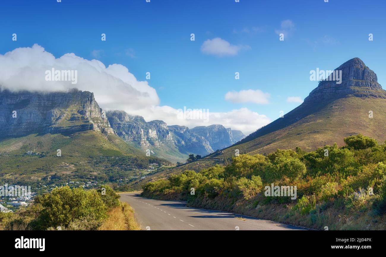 Eine Straße, die nach Lions Head, Table Mountain und The Twelve Apostles in Kapstadt, Südafrika, führt. Gipfel und üppige grüne Landschaft auf einem sonnigen, ruhigen Stockfoto