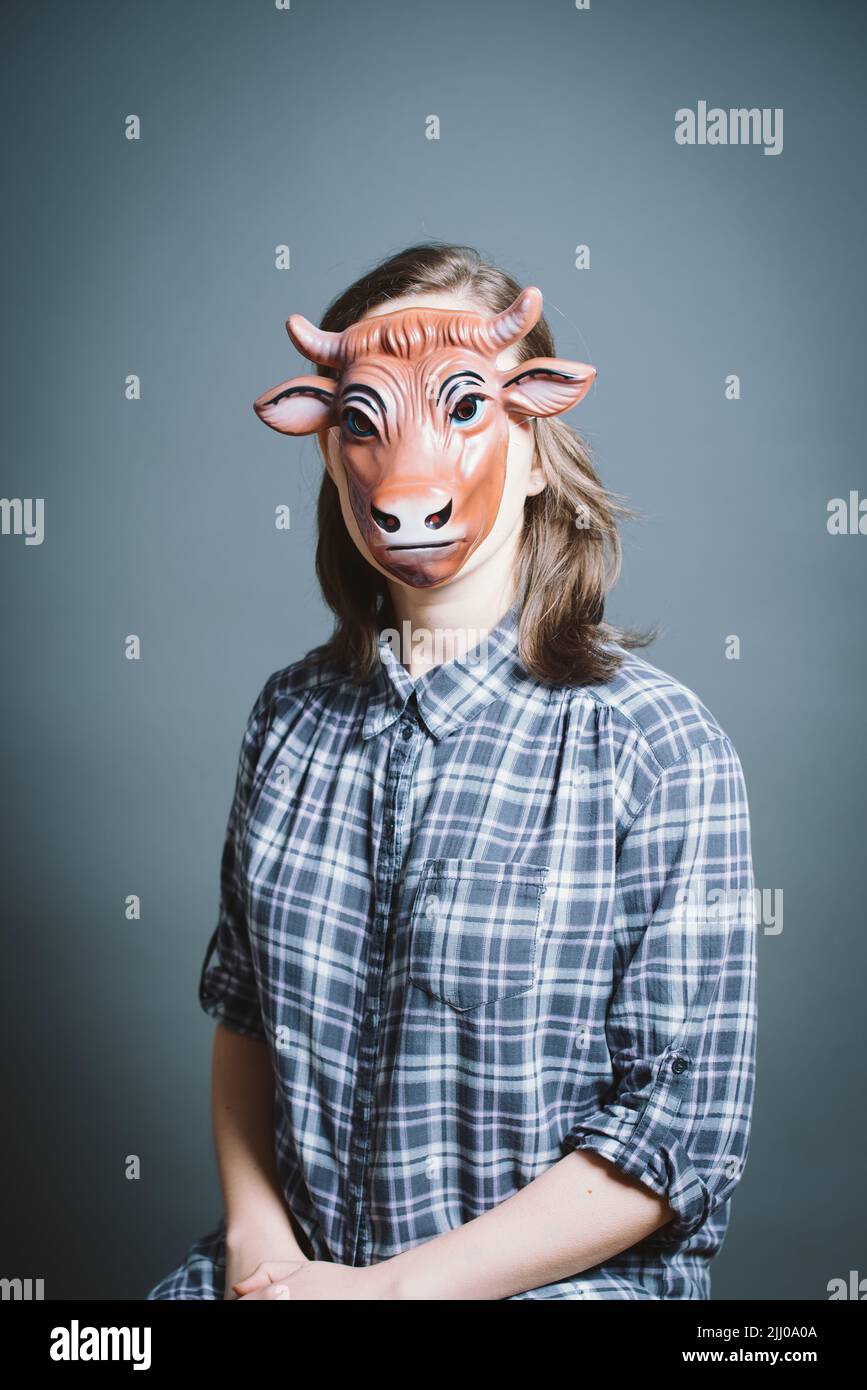 Junge Frau mit Maske vor grauem Hintergrund im Studio Stockfoto