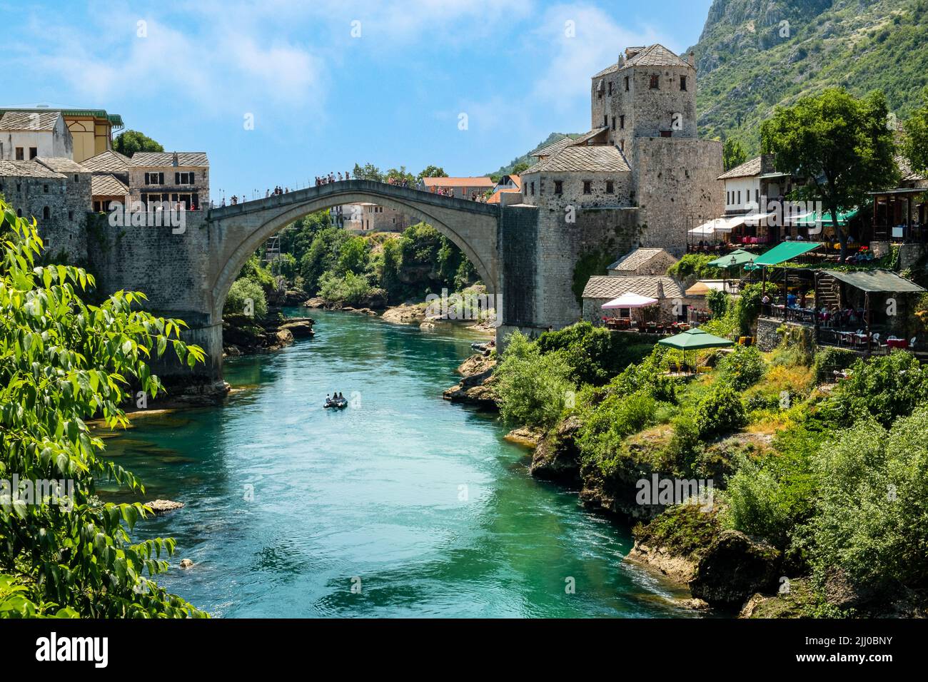 Die Menschen auf der Mostar-Brücke beobachten die Bootsfahrer auf dem Neretva-Fluss Stockfoto