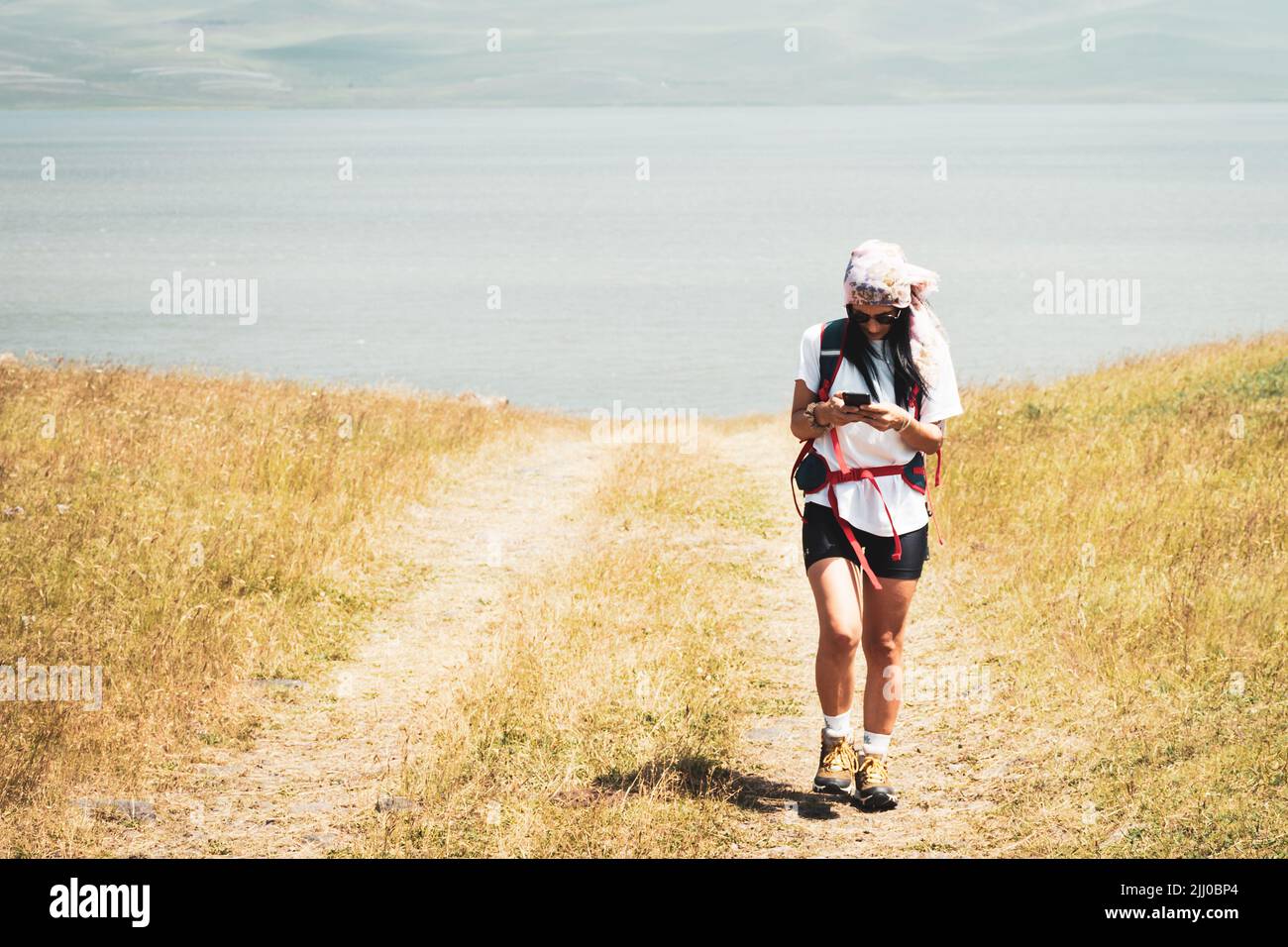 Frau nutzen die Telefonnavigation im Freien, um auf dem Wanderweg zu navigieren, um das Ziel in den kaukasus-Bergen zu erreichen Stockfoto