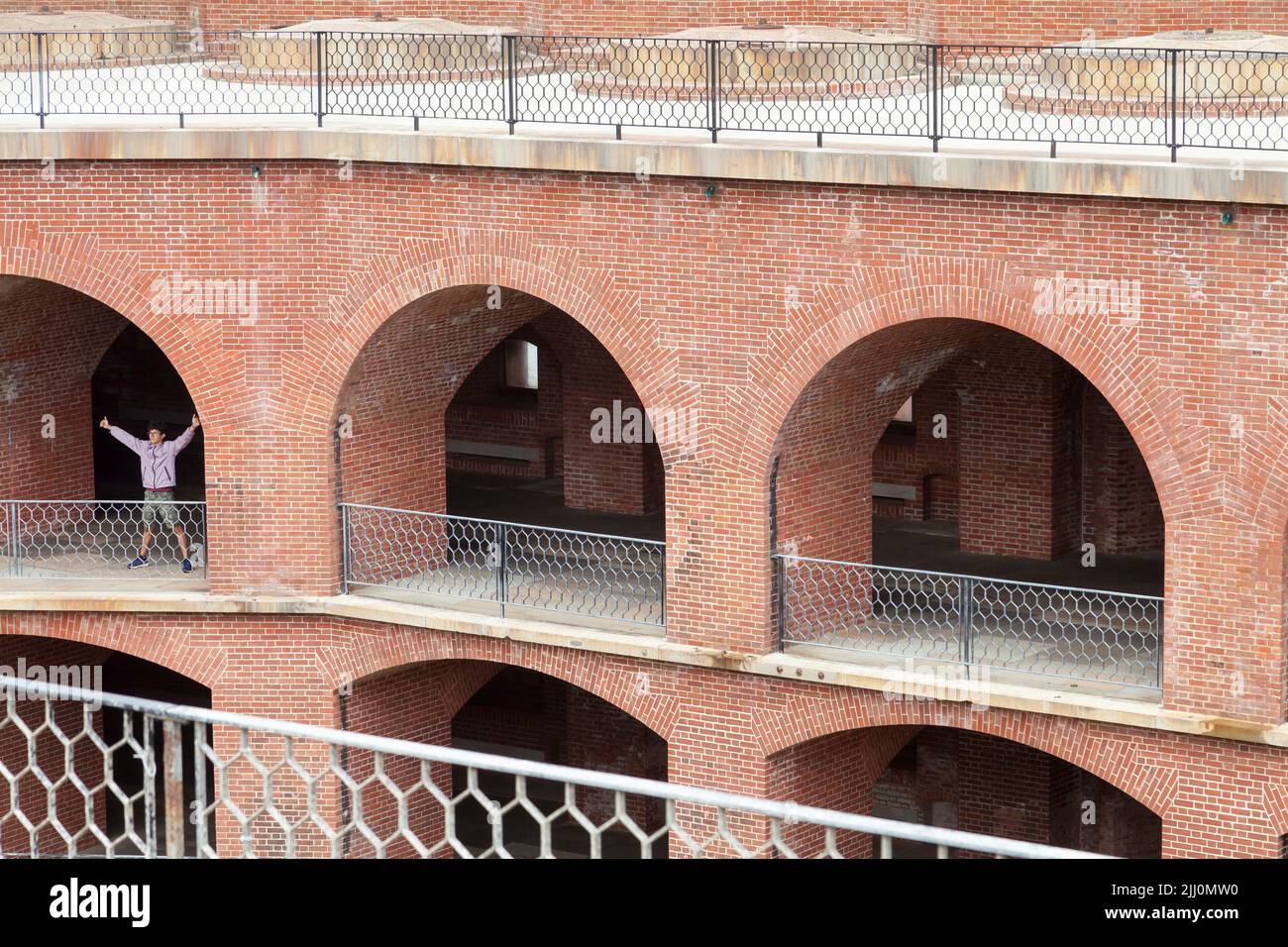 Mann, der glücklich ist, posiert auf dem gewölbten Balkon von Fort Point, San Francisco, Kalifornien, USA Stockfoto
