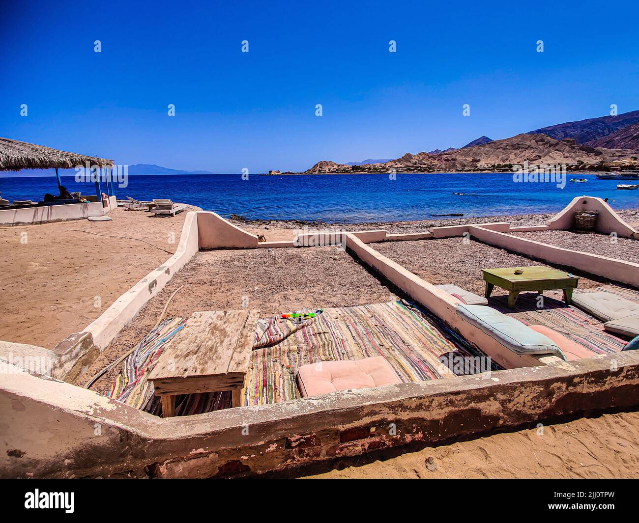 Ferienhaus in einem Beduinenlager am Meer in Ras Shitan in Oasis im Sinai, Taba Wüste mit dem Hintergrund des Meeres und der Berge. Stockfoto