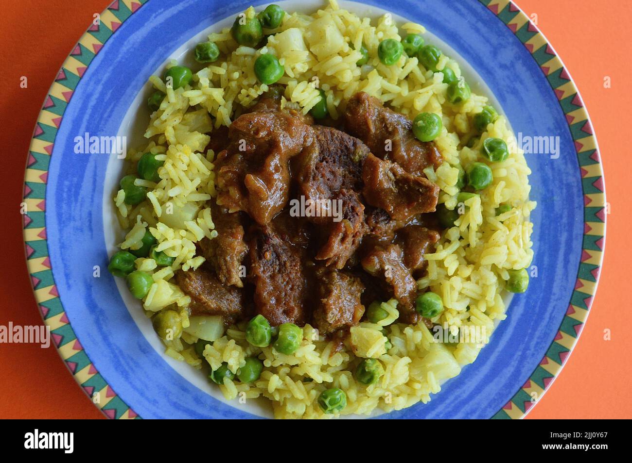 Rindfleisch Korma serviert auf einem bunten Teller Stockfoto