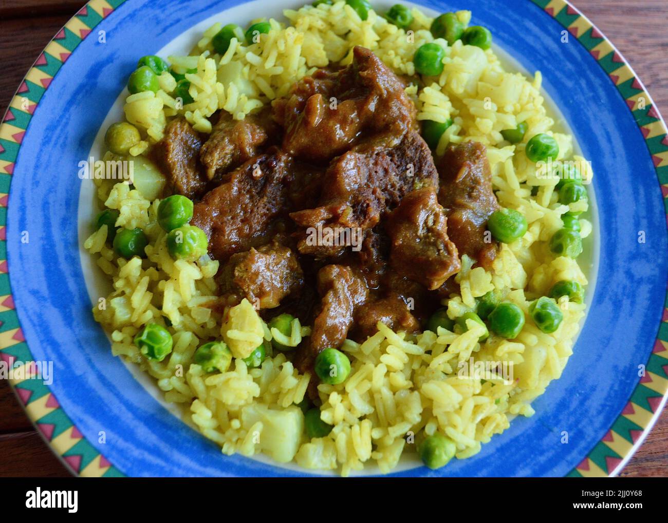 Rindfleisch Korma serviert auf einem bunten Teller Stockfoto