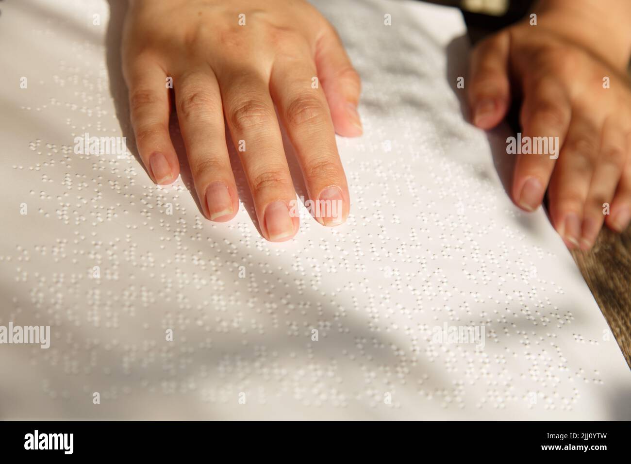 Frau legte ihre Hände auf eine Brailleschrift-Seite Stockfoto