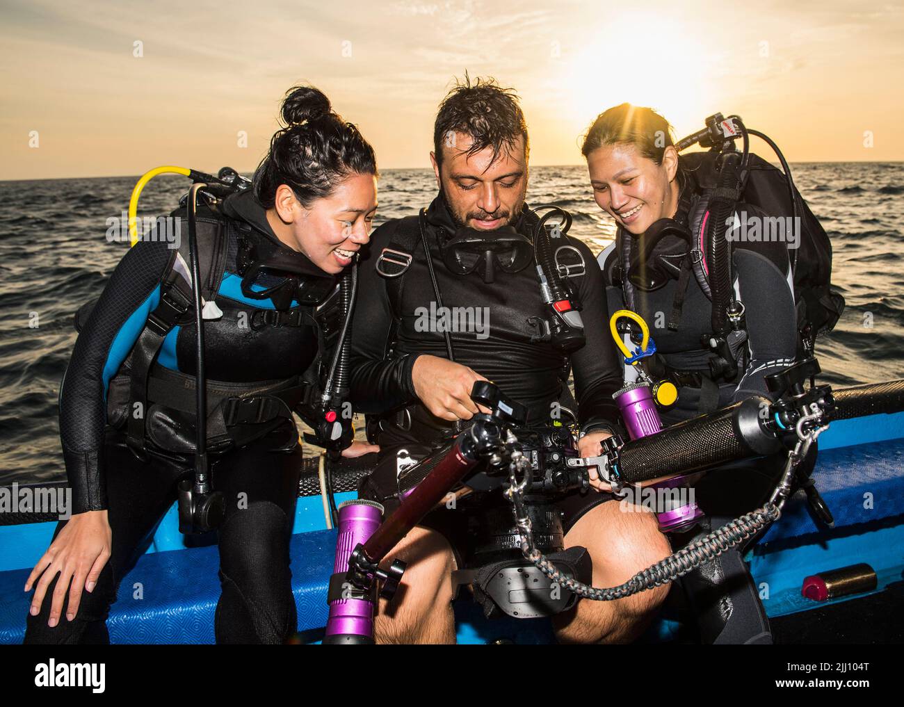 Freunde sehen sich Bilder an der Unterwasserkamera am Tubbataha Riff an Stockfoto