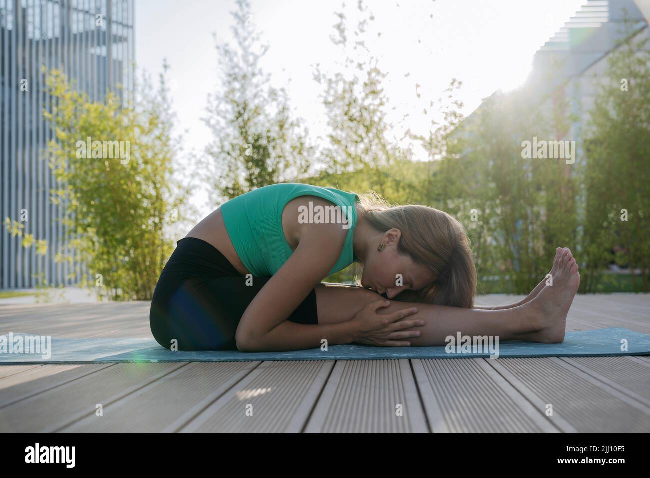 Ein junges athletisches Mädchen dehnt sich auf einer Sportmatte. Stockfoto