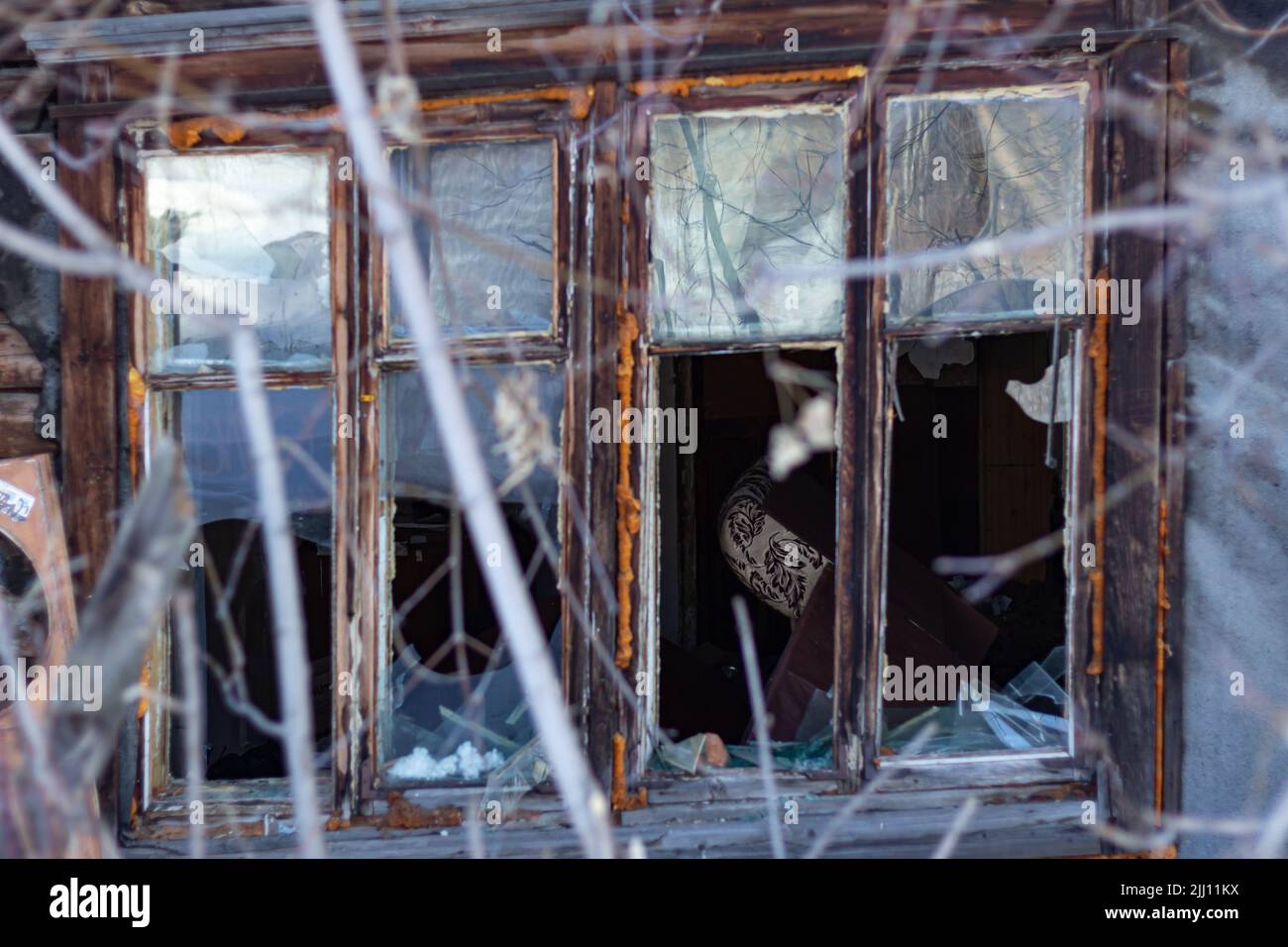 Kaputtes Glasfenster draußen. Nahaufnahme eines alten Holzhauses auf dem Land. Gebäude außen von verlassenen rustikalen Haus. Abstrakter Horror-Hintergrund. Glo Stockfoto