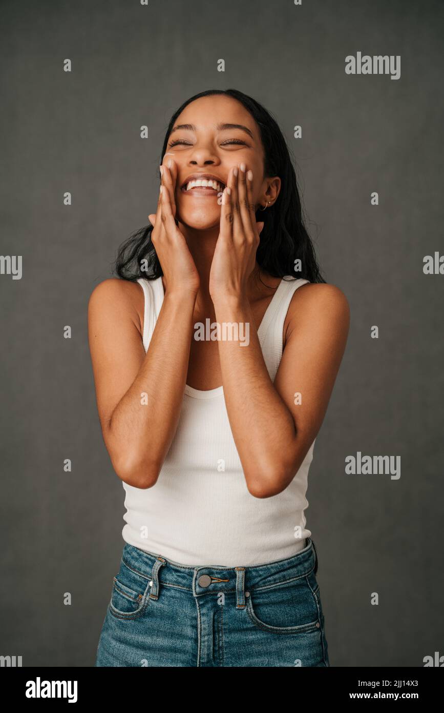 Afroamerikanische Frau, die ihr Gesicht mit den Händen reibt Stockfoto