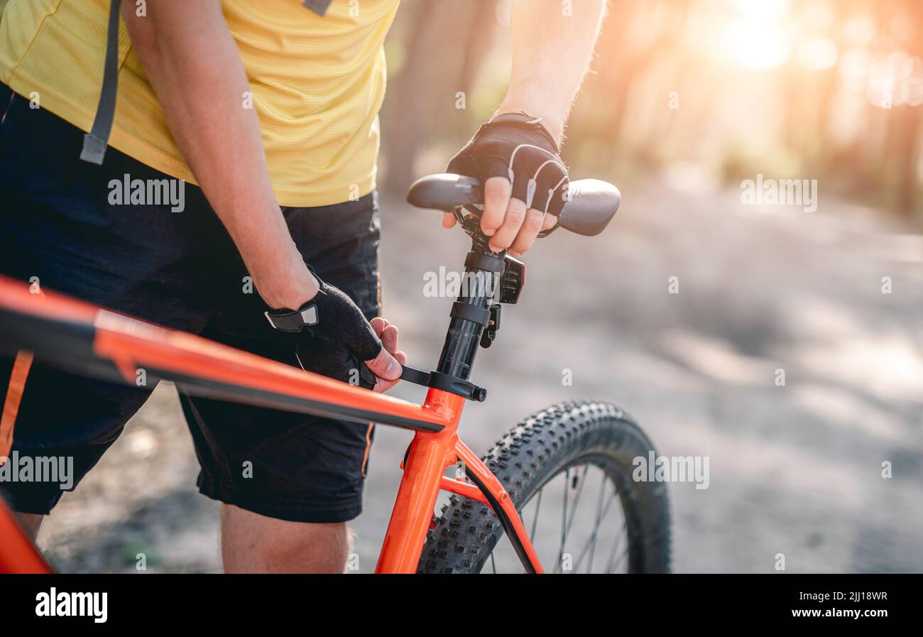 Mann, der die Sitzhöhe des Fahrrads anpasst Stockfoto