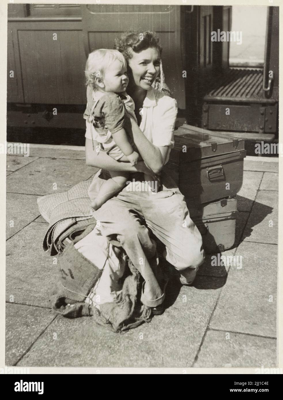 Ein Vintage-Foto um den Februar 1942, das eine britische Frau zeigt, die während der japanischen Invasion von Malaya und dem Fall von Singapur mit ihrem Baby auf dem Bahnhof von Ipoh evakuiert wurde. Stockfoto
