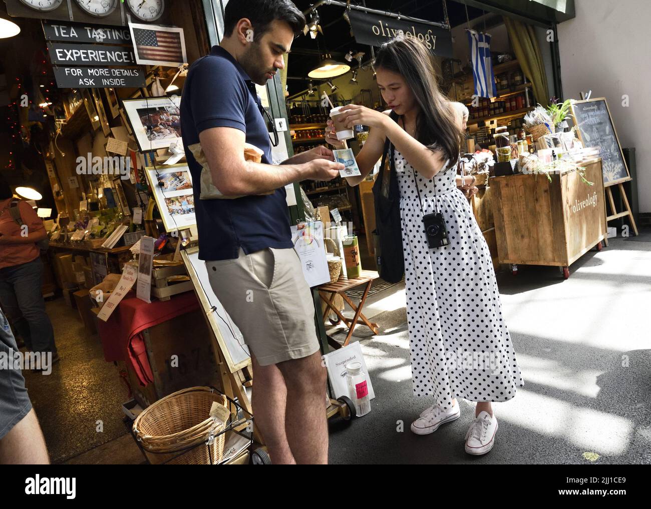 London, England, Großbritannien. Borough Market, Southwark. Ein paar hat nach dem Kauf eines Kaffees den Wechsel sortiert Stockfoto