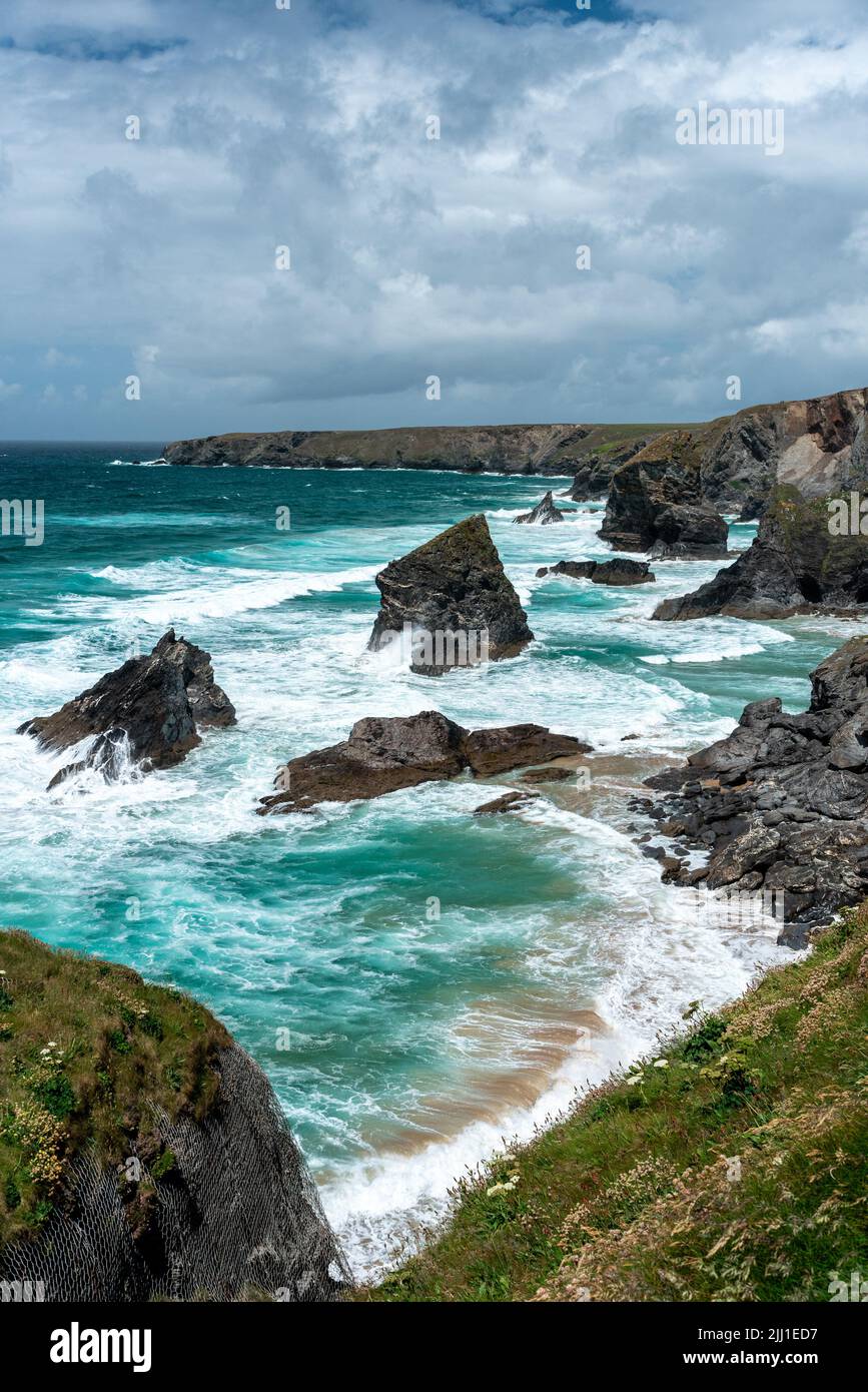 Portraitansicht der stufen von bedruthan Felsen und das blaue Wasser und Wellen um sie herum. Stockfoto