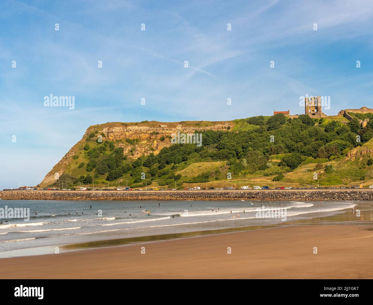 North Bay's Blue Flag Beach mit den Klippen Ruinen von Scarborough Castle in der Ferne. Scarborough, Großbritannien. Stockfoto