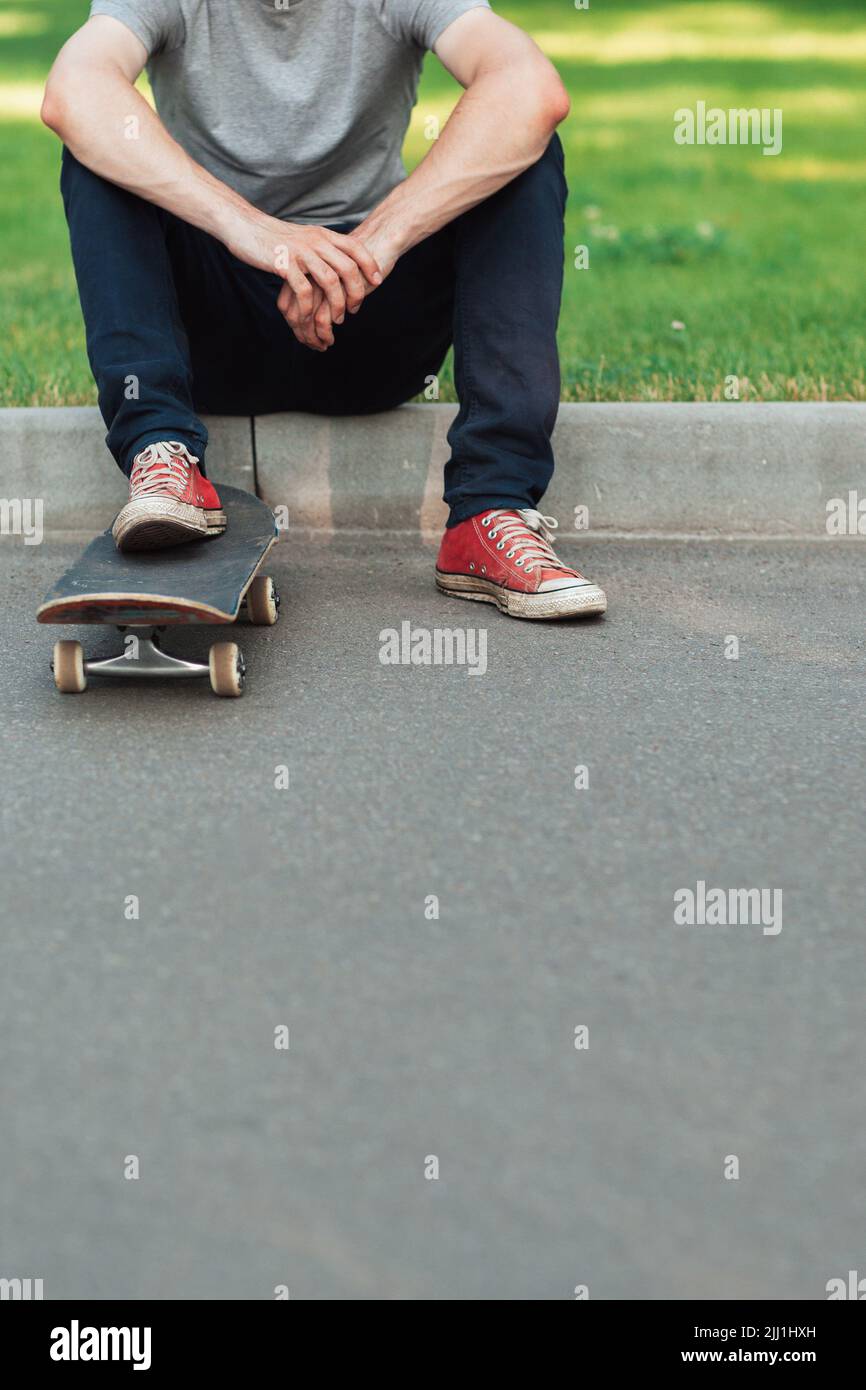 Unverkennbarer Hipster-Mann mit Skateboard Stockfoto