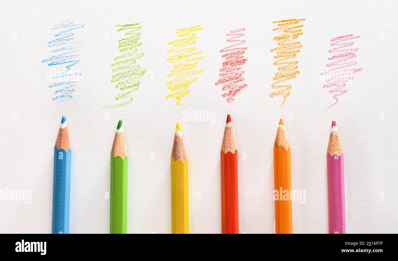Detail verschiedener Buntstifte auf weiß gestreiftem Papier. Draufsicht. Horizontale Zusammensetzung. Stockfoto