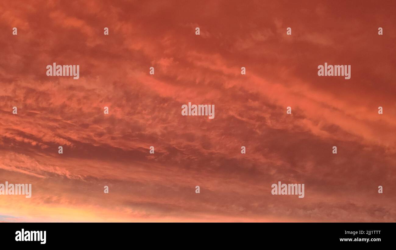 Abstrakter dunkelroter Hintergrund. Dramatischer roter Himmel. Roter Sonnenuntergang mit Wolken. Fantastischer Sonnenuntergang-Hintergrund mit Platz für das Design. Halloween, armageddon Stockfoto