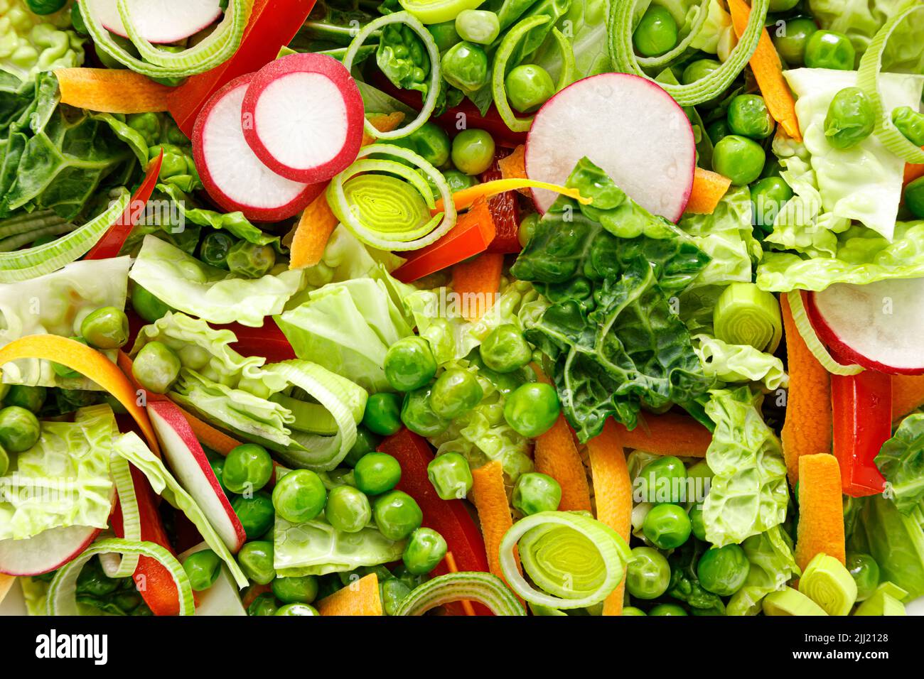 Frischer vegetarischer grüner Salat mit wirsing-Kohl, roher Karotte, Rettich, Paprika, Lauch und grünen Erbsen Stockfoto