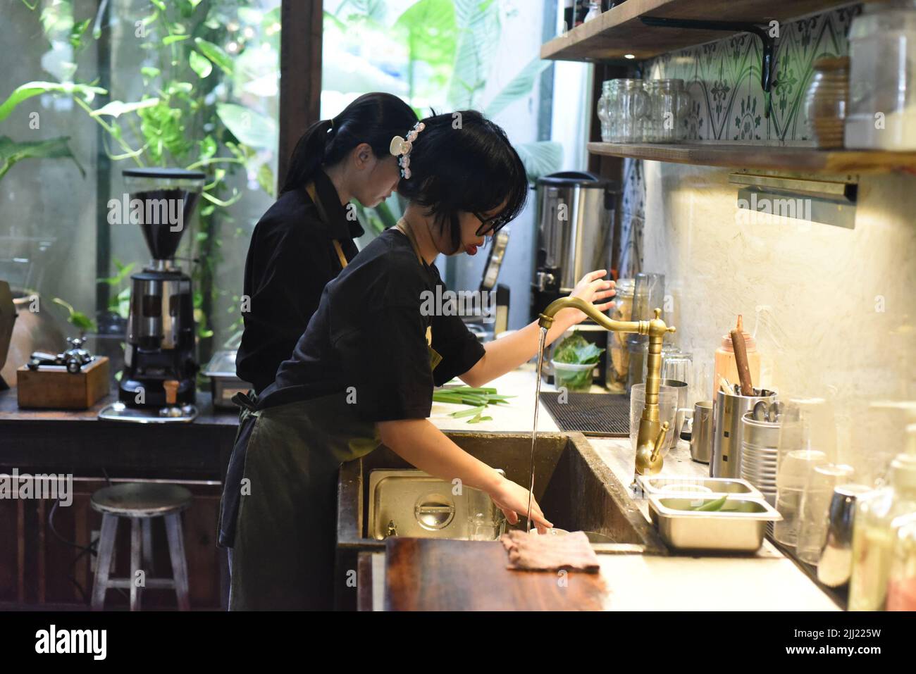 Vietnamesische Kellnerin wascht Geschirr in einem Café Stockfoto