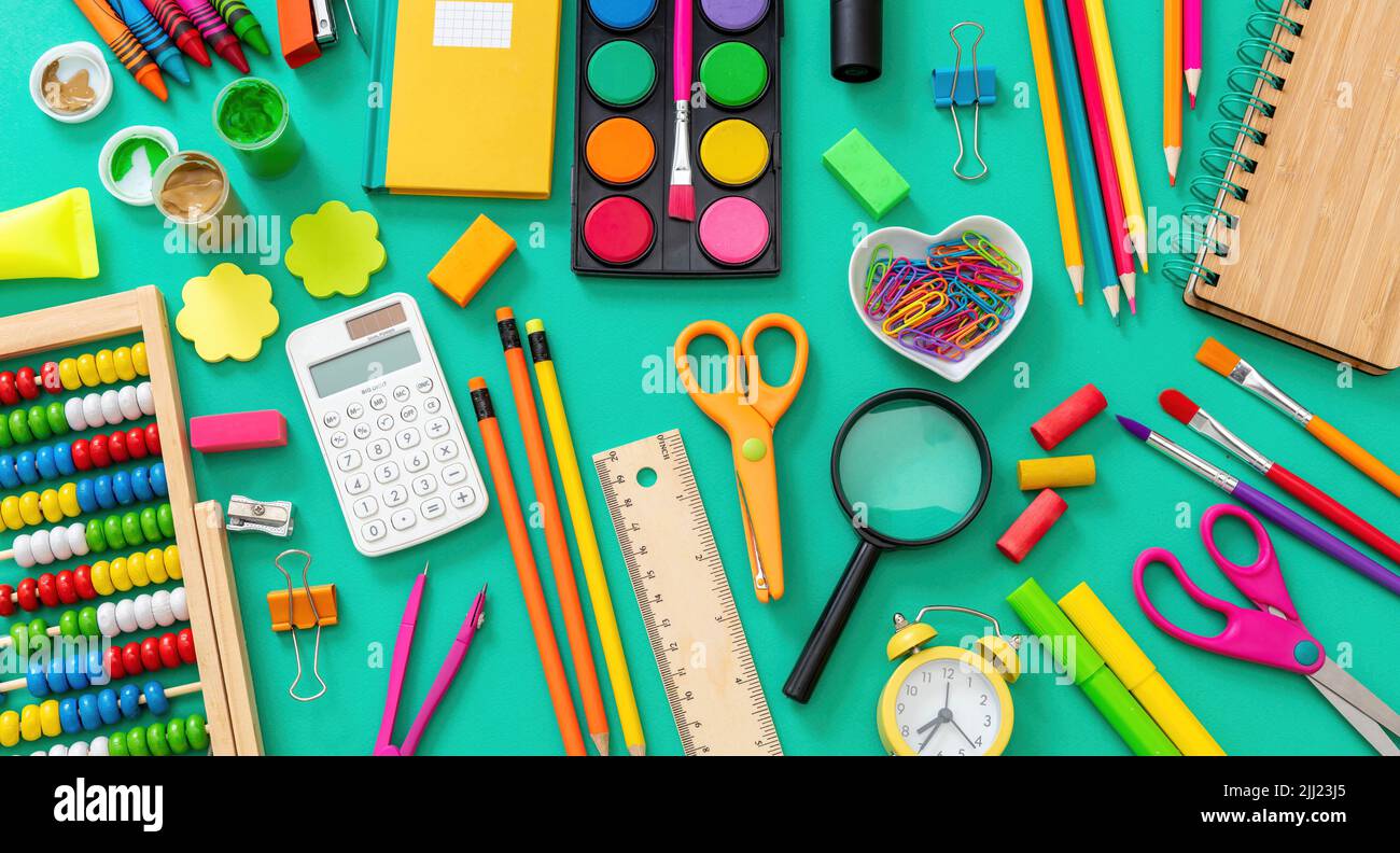Zurück zum Schulhintergrund. Schulbedarf und Schreibwaren flach lagen auf grüner Farbe, Draufsicht. Stockfoto