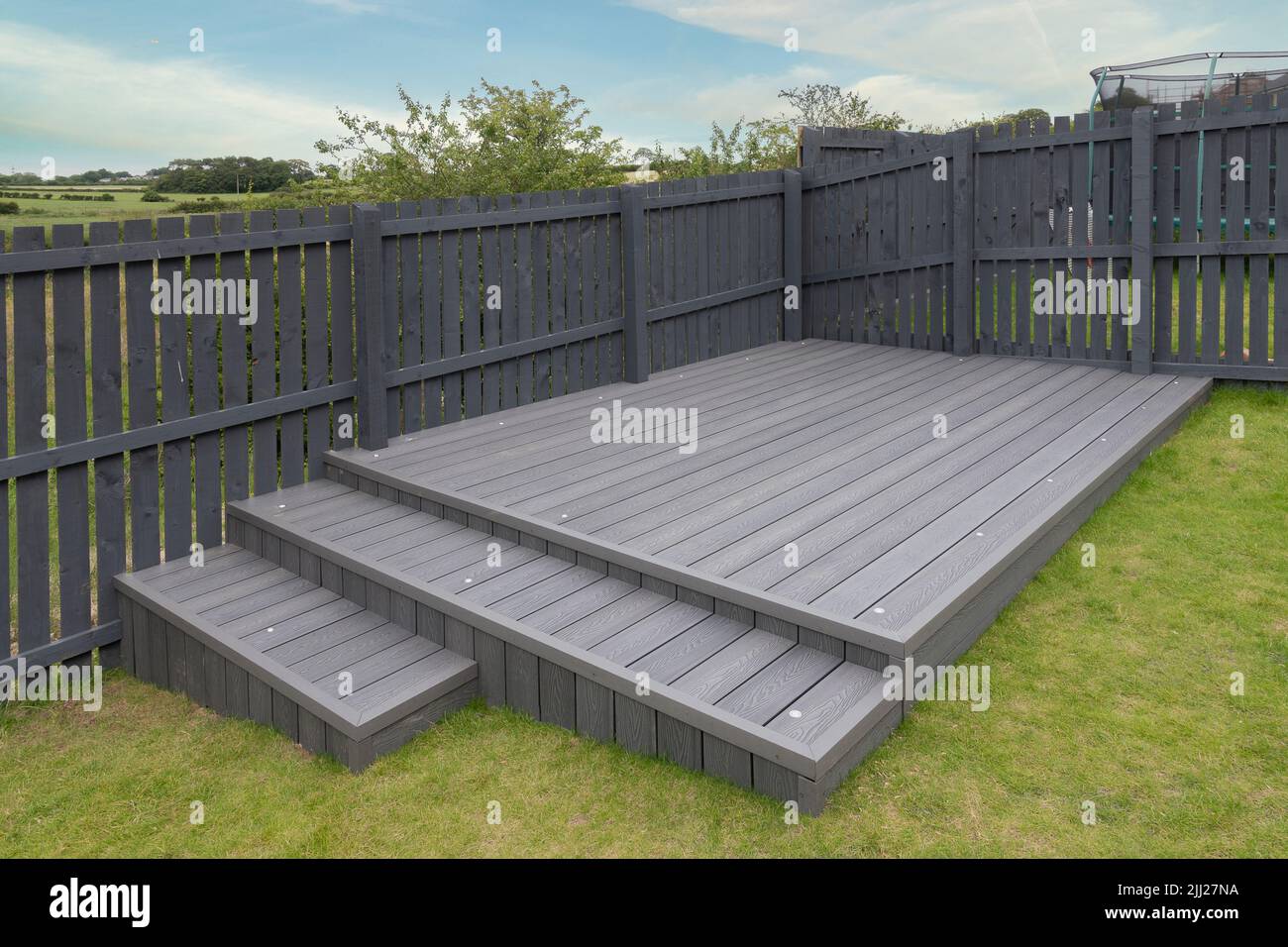 Aschgraue Verbundterrassen, die auf zwei Ebenen in einem Wohngarten mit Niederspannungs-Deckelbeleuchtung errichtet wurden. Gutes Bild für eine Landschaft Stockfoto