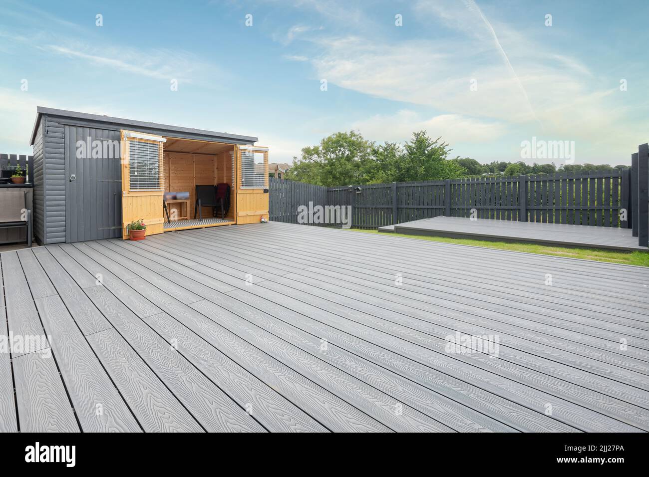 Aschgraue Verbundterrassen, die auf zwei Ebenen in einem Wohngarten mit Niederspannungs-Deckelbeleuchtung errichtet wurden. Gutes Bild für eine Landschaft Stockfoto