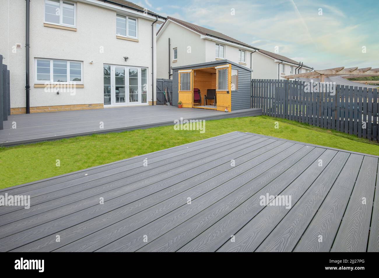 Aschgraue Verbundterrassen, die auf zwei Ebenen in einem Wohngarten mit Niederspannungs-Deckelbeleuchtung errichtet wurden. Gutes Bild für eine Landschaft Stockfoto