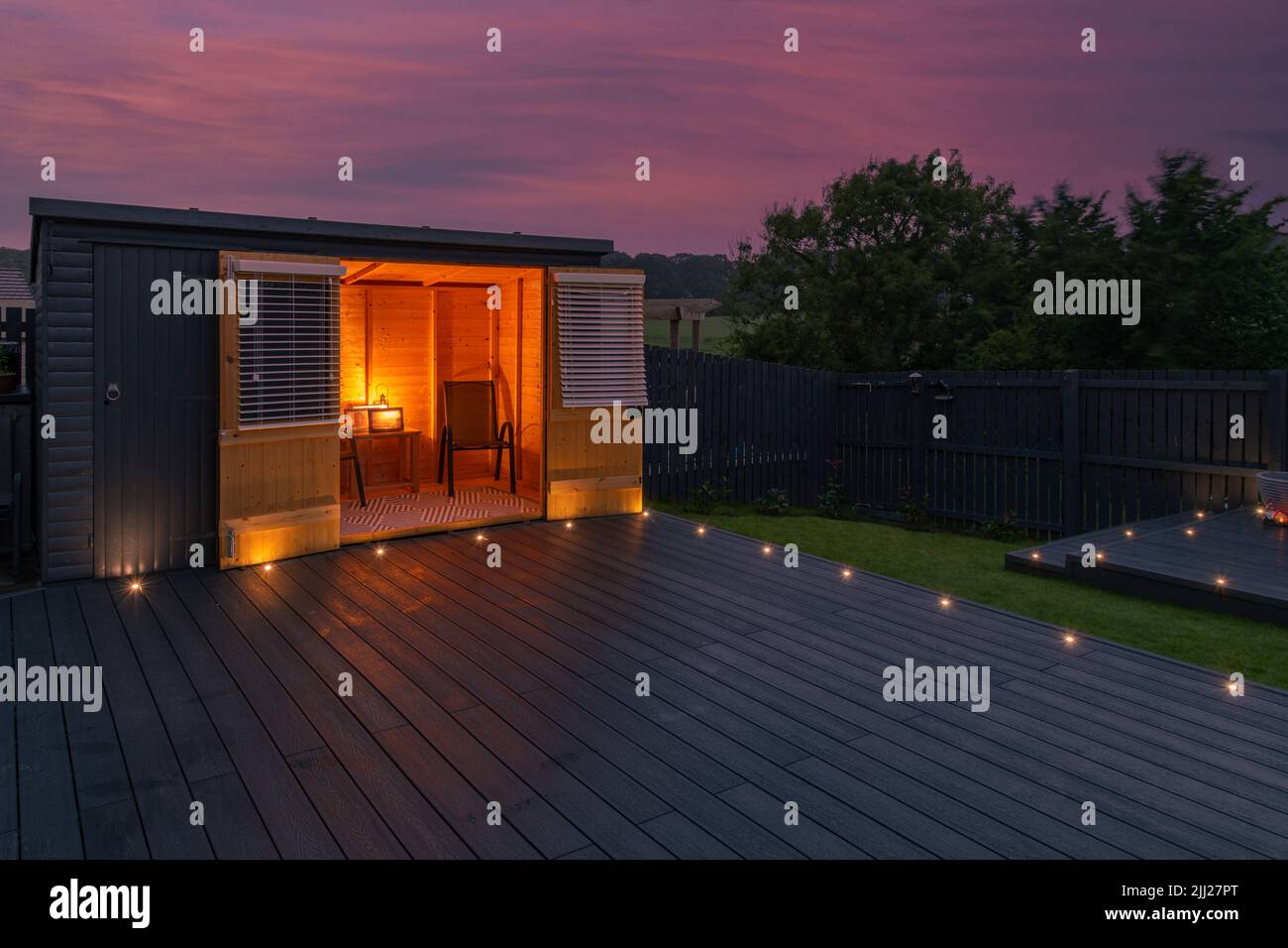 Aschgraue Verbundterrassen, die auf zwei Ebenen in einem Wohngarten mit Niederspannungs-Deckelbeleuchtung errichtet wurden. Gutes Bild für eine Landschaft Stockfoto