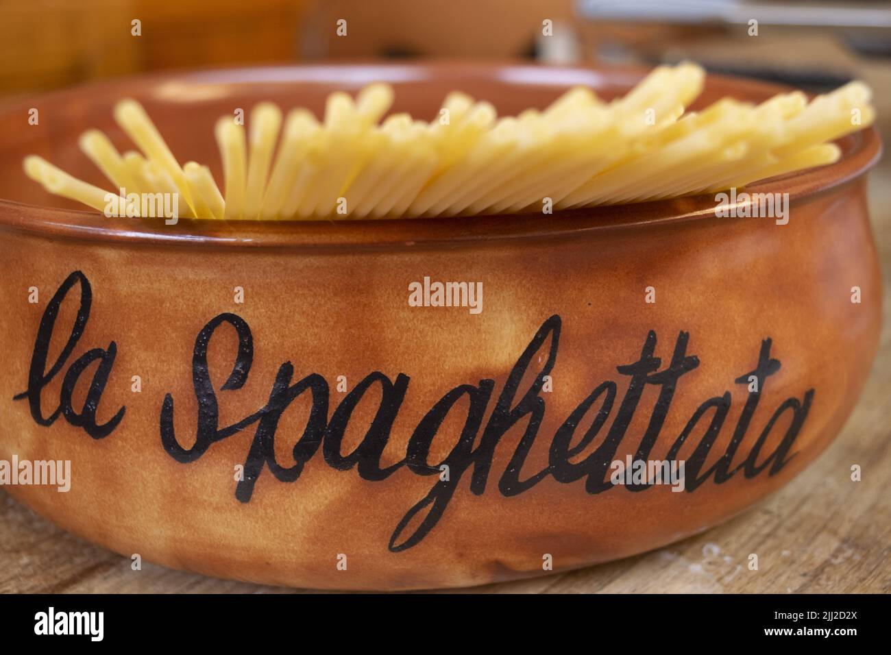 Steingutpfanne mit rohen Spaghetti innen und dem Wort Spaghetti auf einer Seite Stockfoto