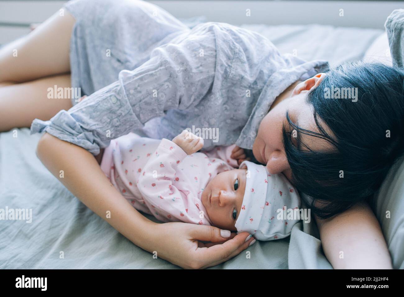 Der Tagesschlaf einer Mutter mit ihrem neugeborenen Baby Stockfoto