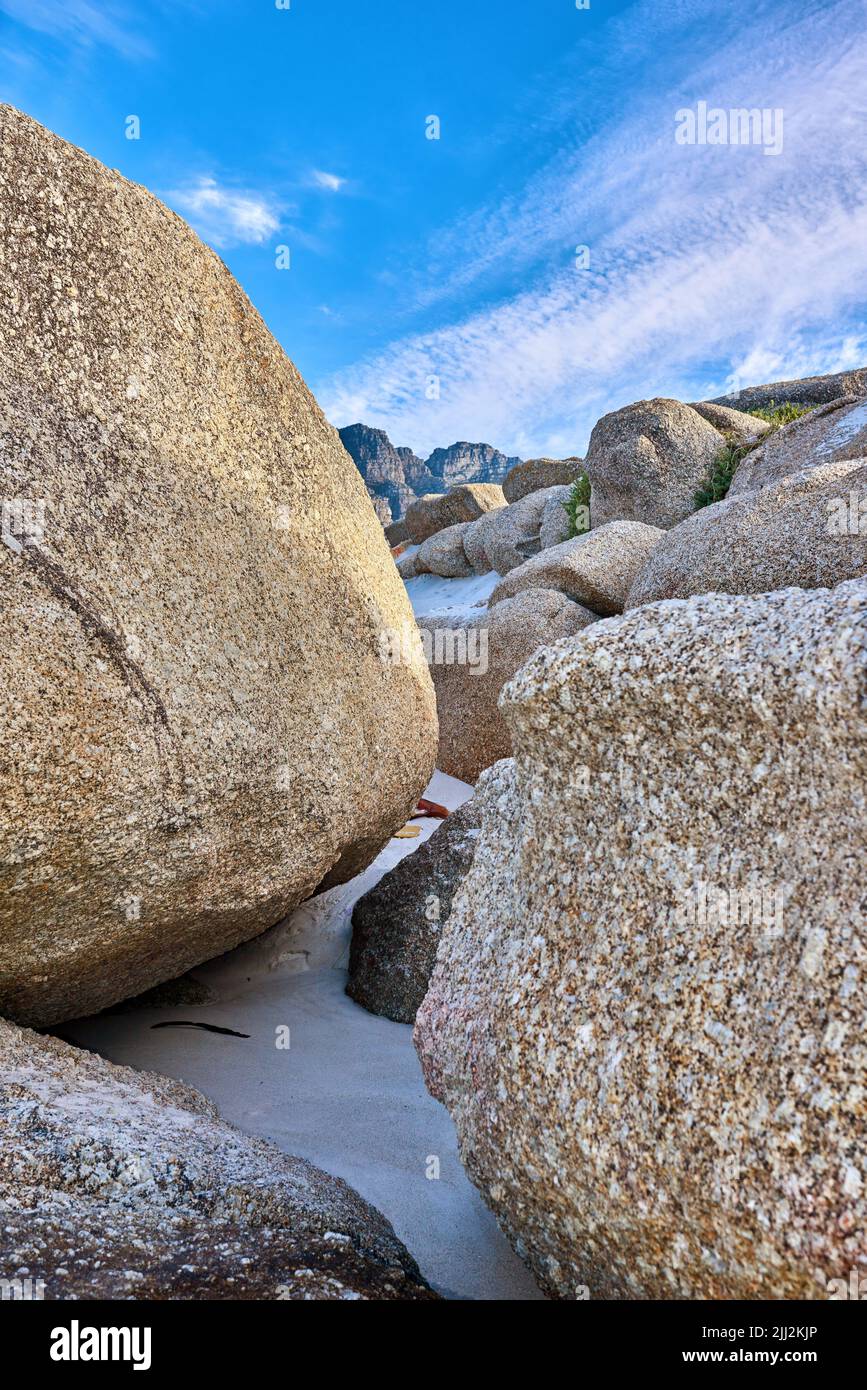 Felsenküste. Große Felsen am Strand mit einem blauen Himmel Hintergrund an einem Sommertag. Eine Landschaft von großen oder riesigen Felsbrocken am Meeresufer eines abgelegenen Stockfoto