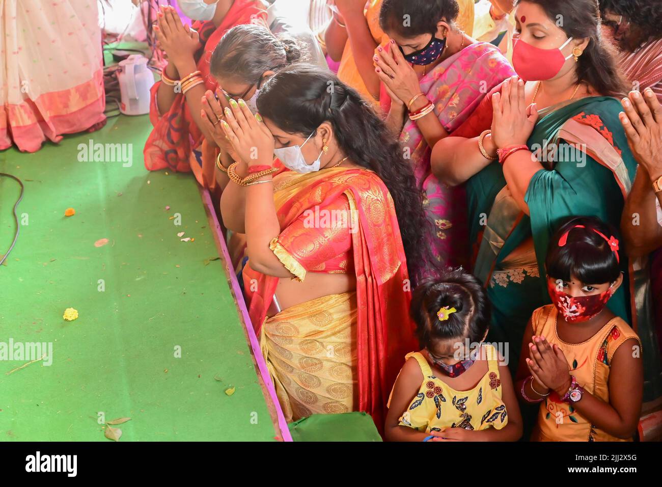 Howrah, Westbengalen, Indien - 14.. Oktober 2021 : Hindu-Anhänger, die der Göttin Durga Pushpanjali anbieten, ein Ritual, um die Göttin mit Blumen zu verehren. Stockfoto