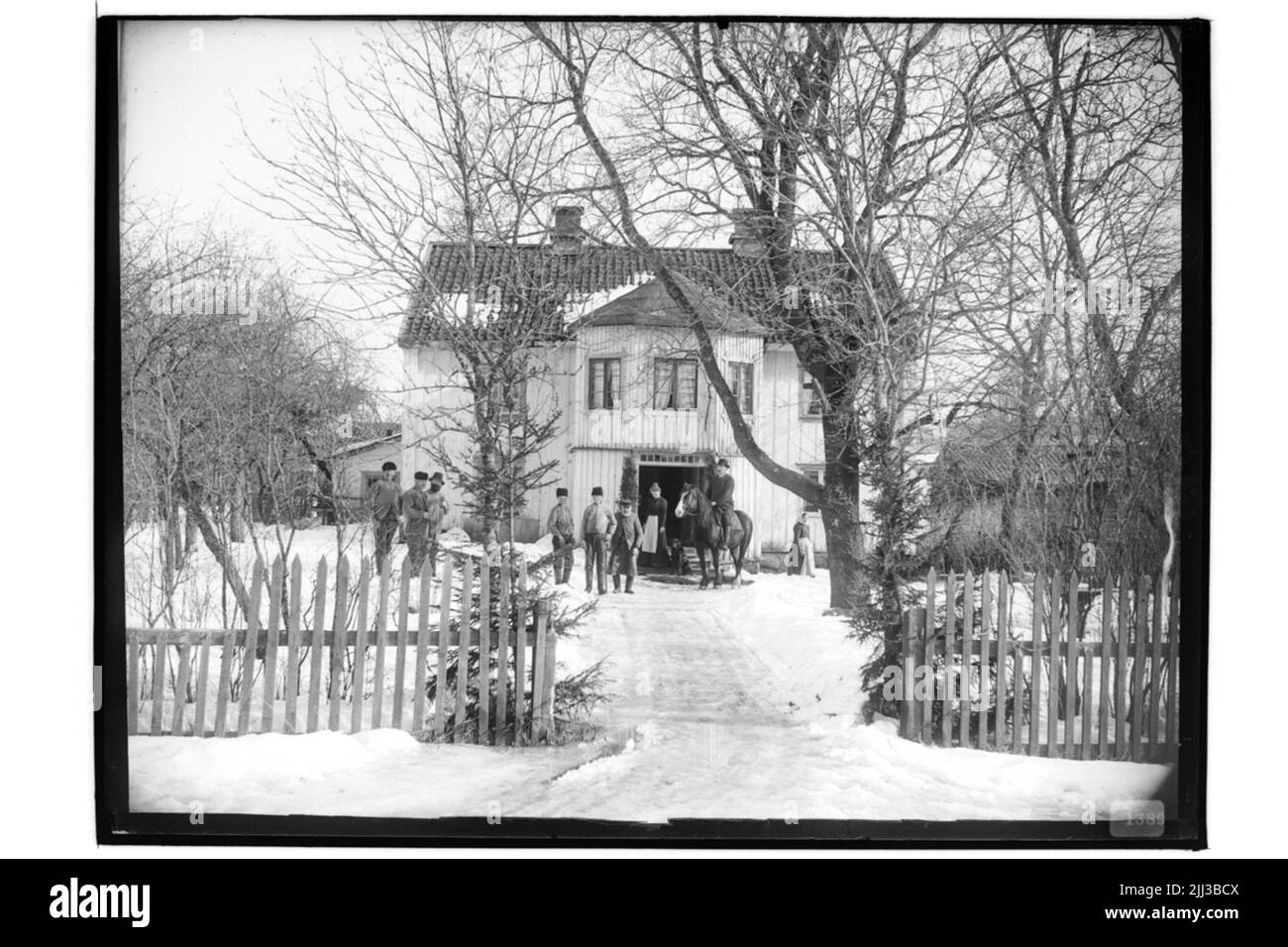 Zweistöckiges Wohnhaus, 9 Personen, einer davon zu Pferd. Stockfoto