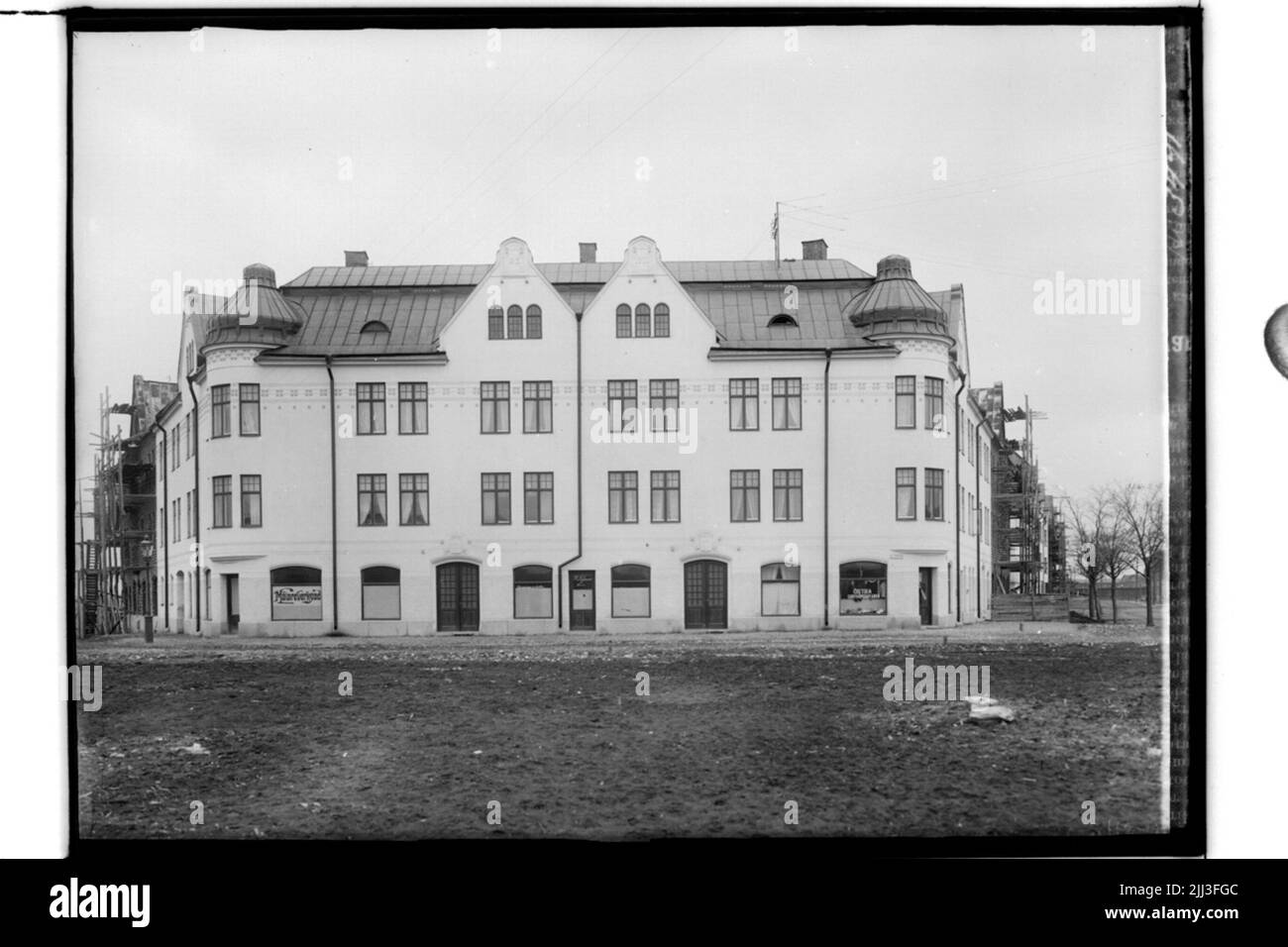 Das Eckhaus in OskaStorget, dreistöckiges Mehrfamilienhaus mit vorderen Öfen, zwei Turmhauben, kaputtes Blechdach. Stockfoto