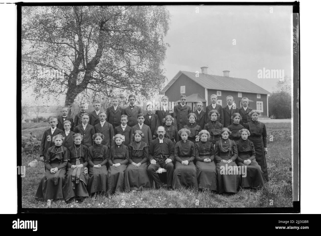 Confirmants, 32 lesenKinder und ein Priester.Eineinhalb Stockwerke hohe Wohnanlage. Stockfoto