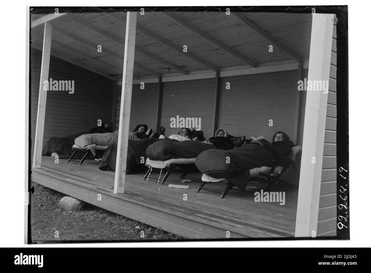 Hålhult Sanatorium, außen, vier Frauen, die in einer Waldhalle liegen Stockfoto