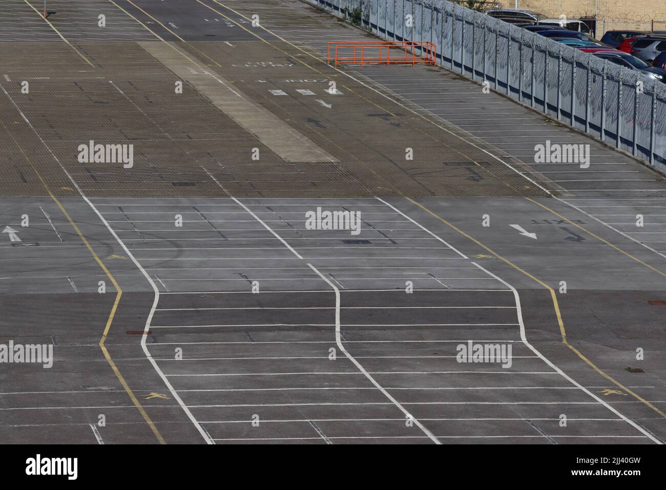 Parkplätze sind auf einer großen Fläche von Asphalt markiert. Sechs Schächte sind versetzt zurückversetzt, was die Illusion eines großen Geschwindigkeitsüberhöhens gibt Stockfoto